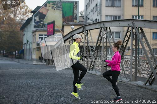 Image of couple warming up before jogging