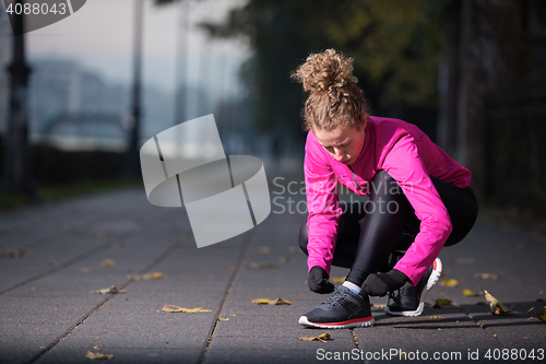 Image of woman  stretching before morning jogging