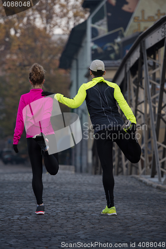 Image of couple warming up before jogging