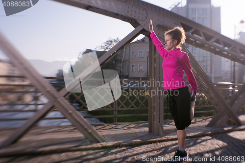 Image of woman  stretching before morning jogging