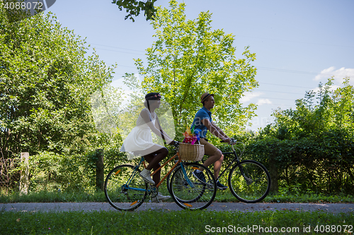 Image of Young multiethnic couple having a bike ride in nature