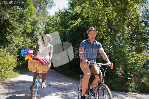 Image of Young multiethnic couple having a bike ride in nature