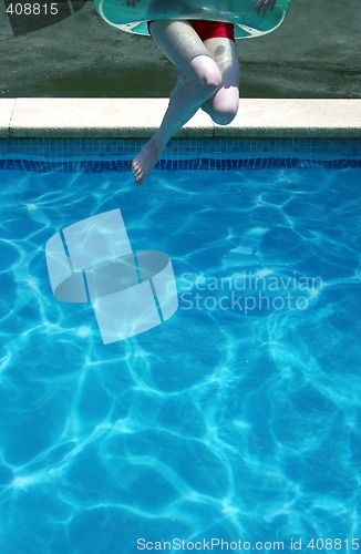 Image of Young woman jumping in swimming pool