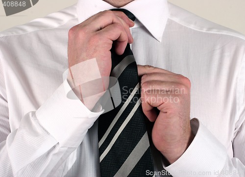 Image of Business man adjusting tie