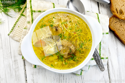 Image of Soup with champignons and noodles in bowl on board top