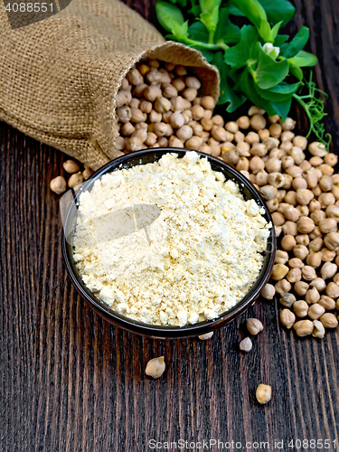 Image of Flour chickpeas in bowl with peas on dark board