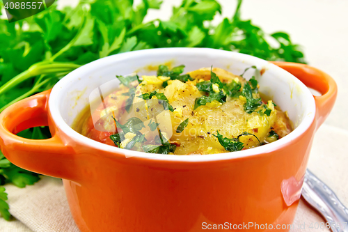 Image of Fish baked with tomato in red pot on table