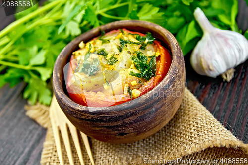 Image of Fish baked with tomato in clay bowl on board