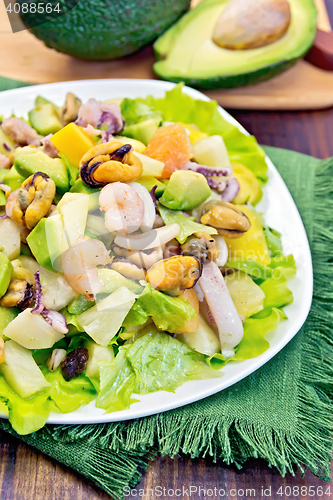 Image of Salad with seafood and avocado in plate on board