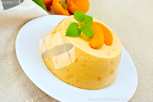 Image of Panna cotta apricot with mint and napkin on table