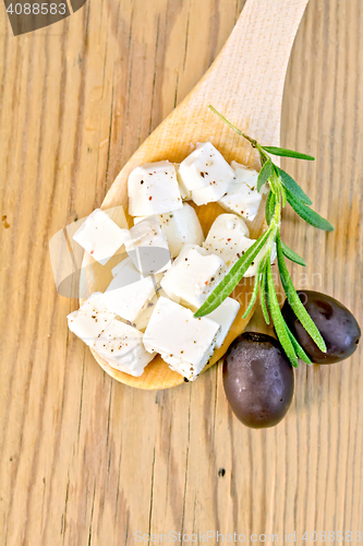 Image of Feta with olives in spoon on board