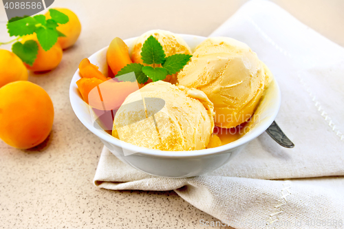 Image of Ice cream apricot with mint in white bowl on napkin