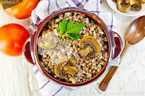 Image of Buckwheat with mushrooms in clay bowl on towel top