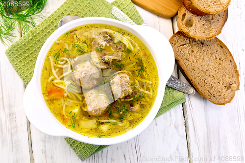 Image of Soup with meatballs and noodles in bowl on napkin top