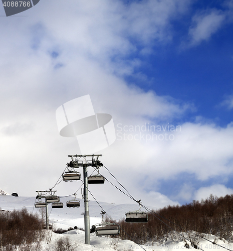 Image of Chair lift on ski resort and snow winter mountain in clouds