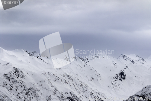 Image of High snowy mountains and gray storm sky before blizzard