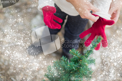 Image of Mother Putting Red Mittens On Child with Snow Effect