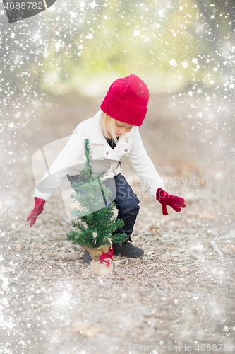Image of Girl In Red Mittens and Cap Near Small Christmas Tree with Snow 
