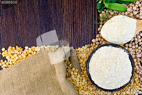 Image of Flour pea in spoon and chickpeas in bowl on board