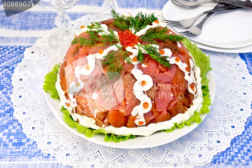 Image of Salad with salmon in plate on blue tablecloth