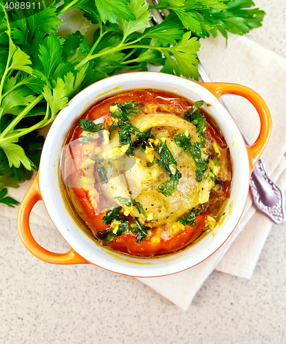 Image of Fish baked with tomato in red pot on table top