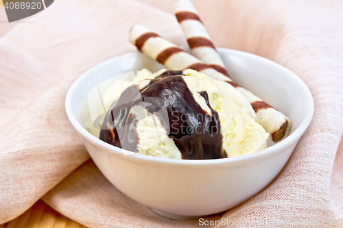 Image of Ice cream vanilla with wafer rolls on napkin