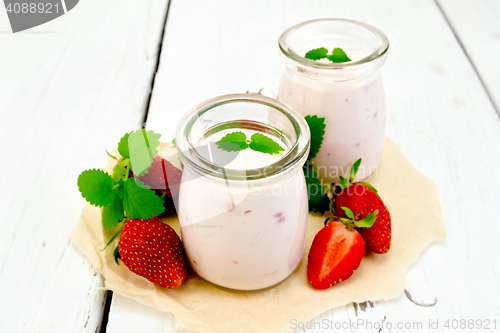 Image of Yogurt with strawberries in jar on paper