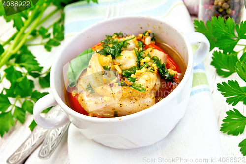 Image of Fish baked with tomato and spices in white bowl on board