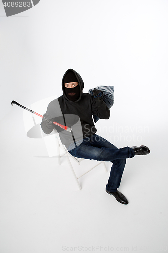 Image of Robber sitting on white chair