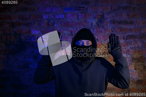 Image of Surprised thief with hands up