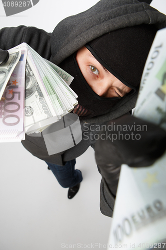 Image of Burglar in gloves with money