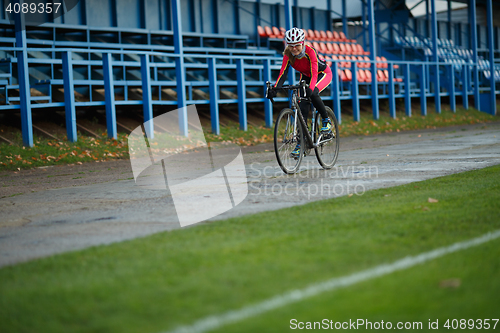 Image of Athletic young woman riding bicycle on the road