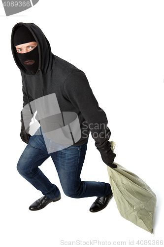 Image of Thief in mask carries bag