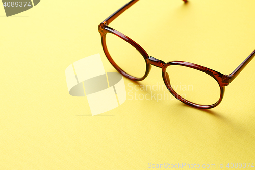 Image of Brown glasses on yellow background