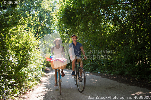 Image of Young multiethnic couple having a bike ride in nature