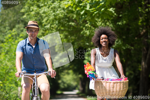 Image of Young multiethnic couple having a bike ride in nature