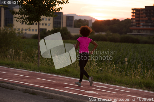 Image of a young African American woman jogging outdoors