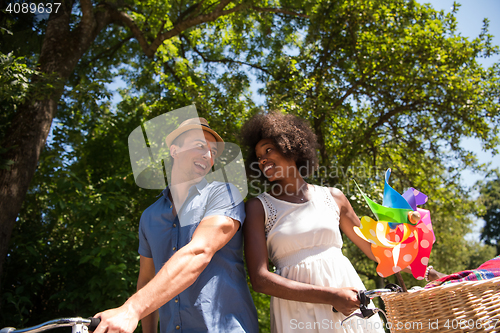 Image of Young multiethnic couple having a bike ride in nature