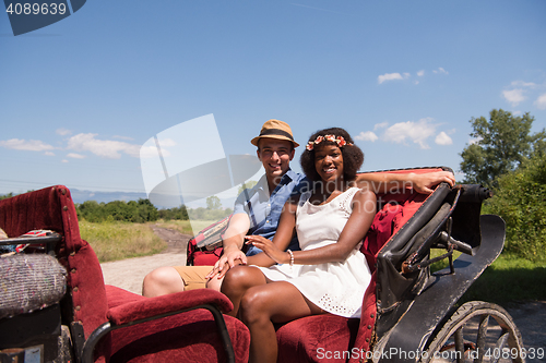 Image of multiethnic couple sitting in a horse carriage