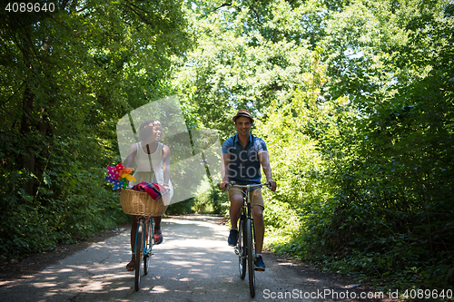 Image of Young multiethnic couple having a bike ride in nature