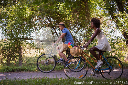 Image of Young multiethnic couple having a bike ride in nature
