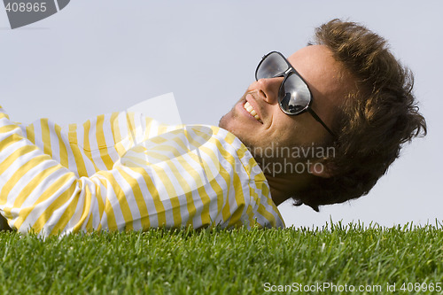 Image of Young man lying down on the grass