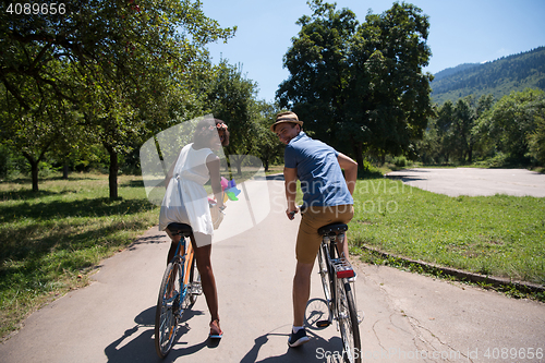 Image of Young multiethnic couple having a bike ride in nature