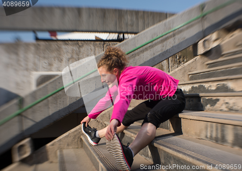 Image of woman  stretching before morning jogging