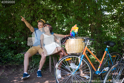 Image of Young multiethnic couple having a bike ride in nature