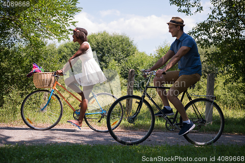 Image of Young multiethnic couple having a bike ride in nature