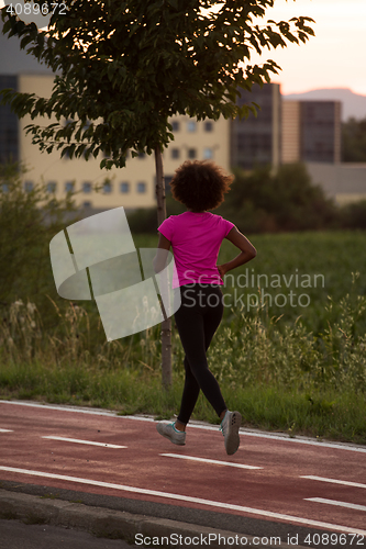 Image of a young African American woman jogging outdoors