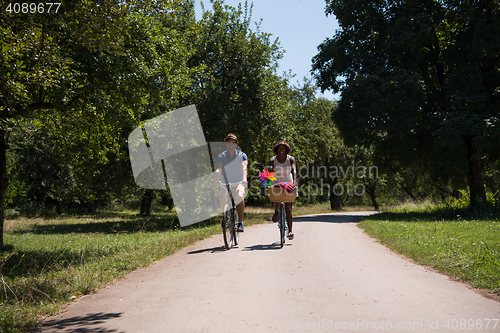 Image of Young multiethnic couple having a bike ride in nature