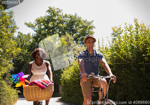 Image of Young multiethnic couple having a bike ride in nature