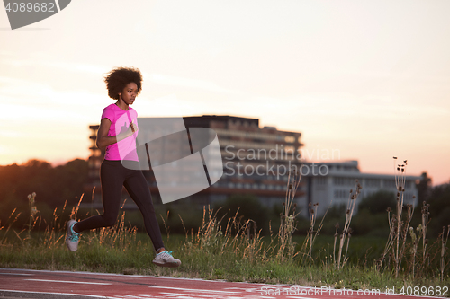 Image of a young African American woman jogging outdoors